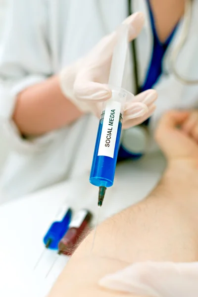 Médecin injectant une seringue au patient. Concept de dépendance aux médias sociaux . — Photo