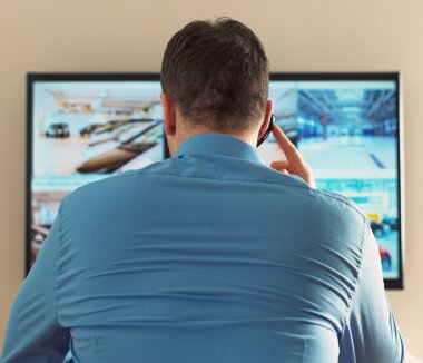 Güvenlik görevlisi güvenlik odasında video izleme. Arkadan.