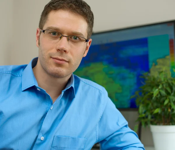 Knappe mannelijke meteoroloog in bril op zijn werkplek. — Stockfoto