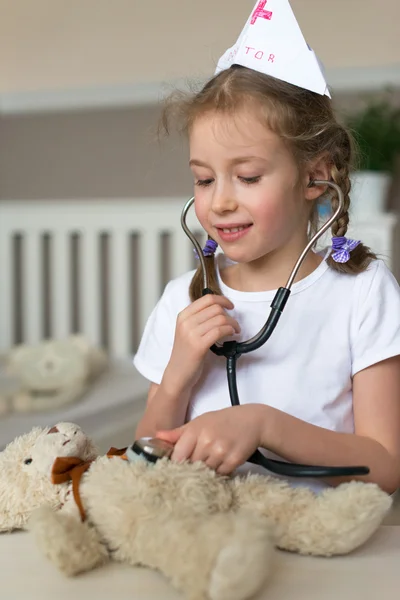 Cute little girl playing in doctor with her toy. — Stock Photo, Image