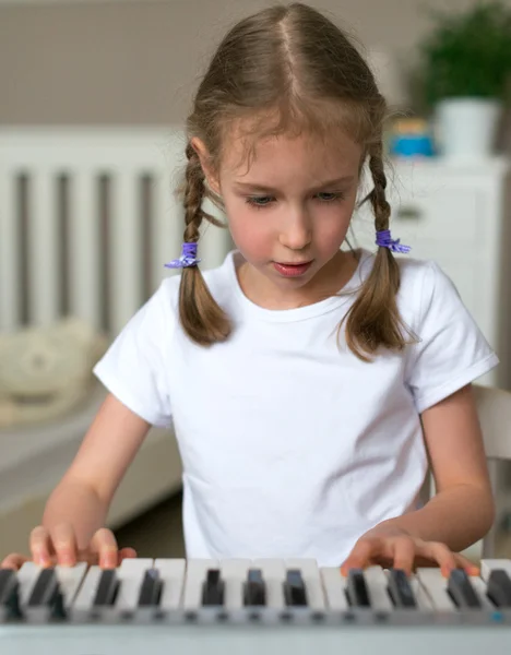 Cute little girl learning to play the piano. — Stock Photo, Image