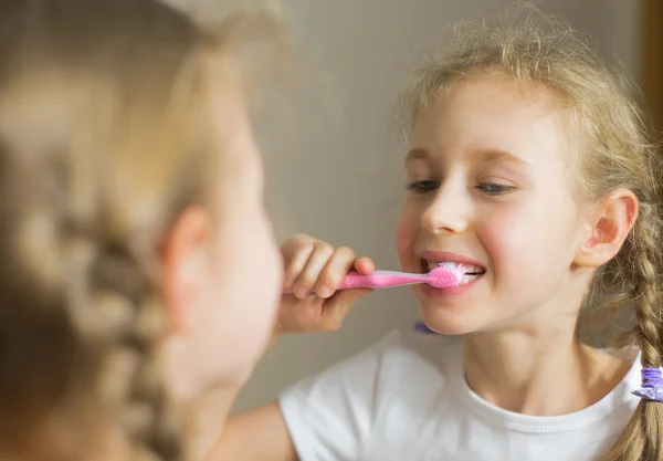 Petite fille se brossant les dents avec une brosse à dents . — Photo