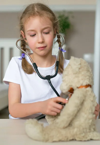 Cute dziewczynka gra w lekarz z jej zabawka. — Zdjęcie stockowe