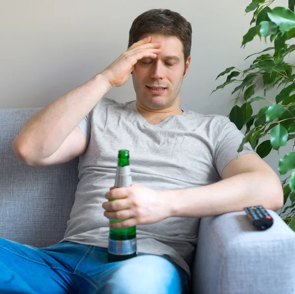 Mann mit Bierflasche schaut Sport im Fernsehen. — Stockfoto