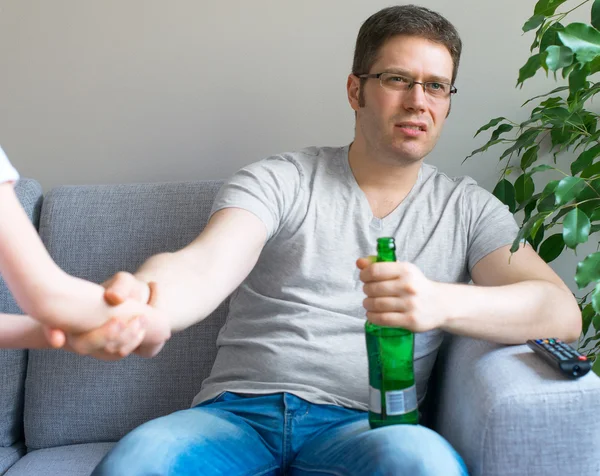 Kleines Mädchen ruft Papa an, um zu spielen, während er fernsieht. — Stockfoto