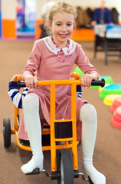 Menina andando de bicicleta no jardim de infância . — Fotografia de Stock