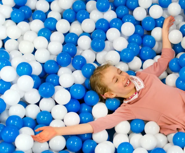 Glückliches kleines Mädchen, das Spaß im Spielzimmer hat. Platz für Text. — Stockfoto