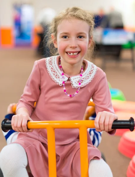 Little girl riding bicycle in kindergarten. — Stock Photo, Image