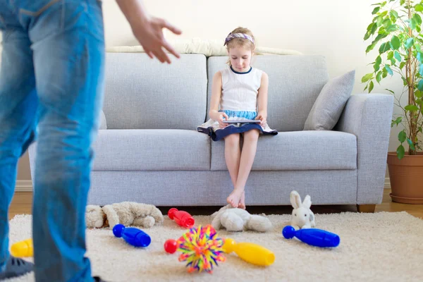 Het is tijd om schoon te maken uw speelgoed! Meisje speelt met de tablet pc, het negeren van haar vader. — Stockfoto