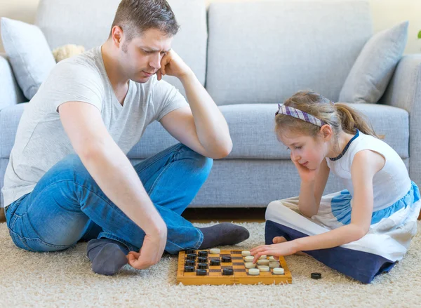 Bambina e suo padre giocano a dama . — Foto Stock