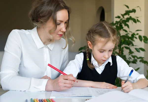 Мати допомагає дочці з домашнім завданням вдома . — стокове фото