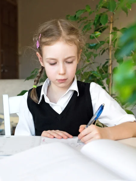 Klein meisje haar huiswerk thuis. — Stockfoto