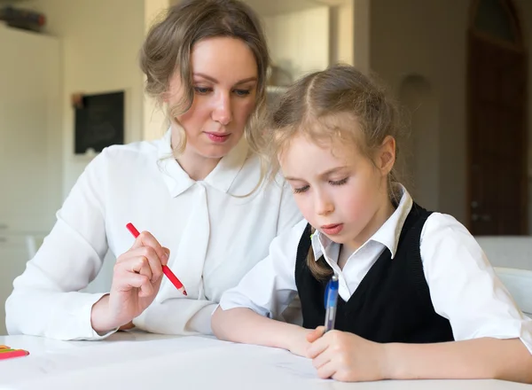 Matka pomáhá dceři s domácím úkolem. — Stock fotografie