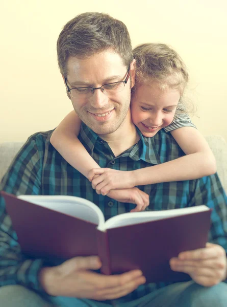 Far läsa bok med dotter hemma. — Stockfoto