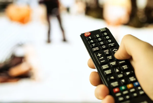 Male hand holding TV remote control. — Stock Photo, Image