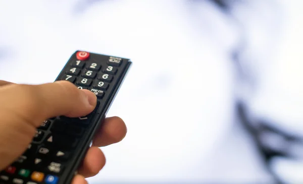 Male hand holding TV remote control. — Stock Photo, Image