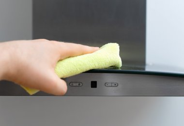 Man's hand wipes dust from exhaust hood. clipart