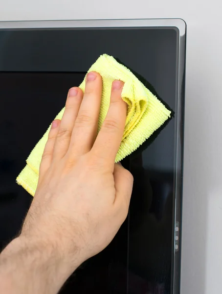 Man's hand wipes dust from TV panel. — Stock Photo, Image