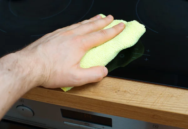 Männerhand wischt Kochplatte in der Küche ab. — Stockfoto