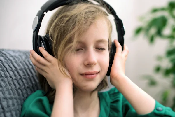Mała dziewczynka słuchanie muzyki w słuchawkach. — Zdjęcie stockowe