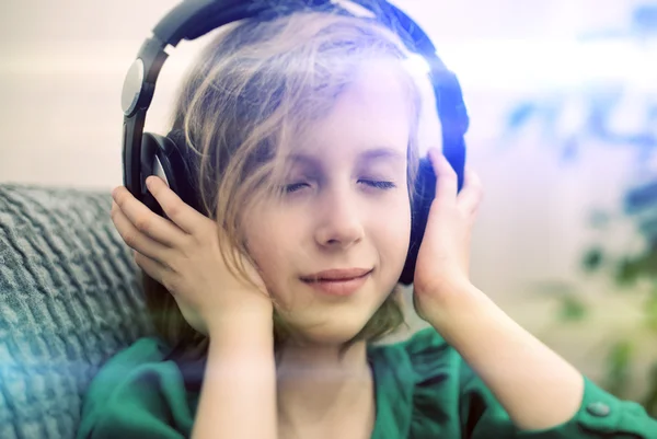 Mała dziewczynka słuchanie muzyki w słuchawkach. — Zdjęcie stockowe