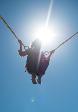 Bungee trambolin halatlar ile küçük kız. Metin için yer.