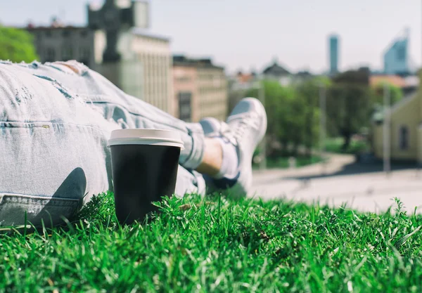 커피 한잔과 함께 잔디에 휴식 하는 여자. — 스톡 사진