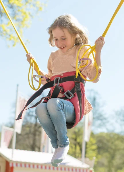 Holčička na bungee trampolíně s šňůry. — Stock fotografie