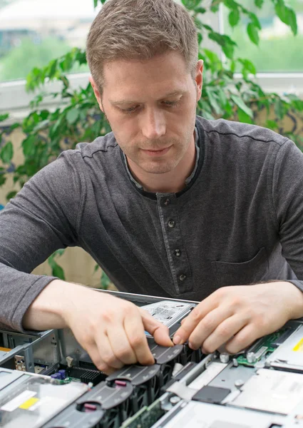 Technicien informatique installant ventilateur refroidisseur dans la carte mère . — Photo