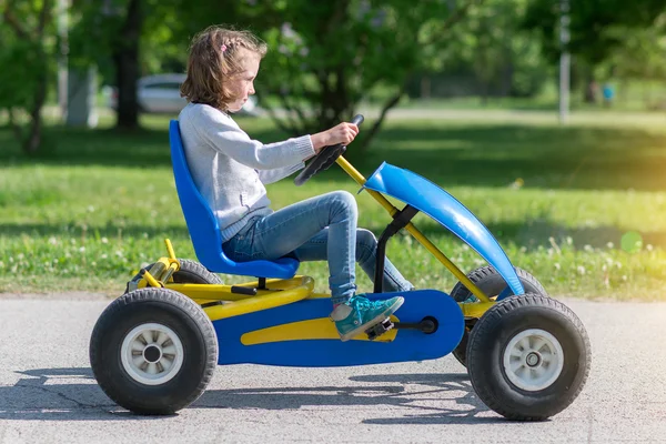 Küçük kız üzerinde pedal karting tesisi. — Stok fotoğraf