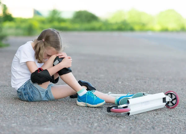 Little girl fell from the scooter on the street. — Stock Photo, Image