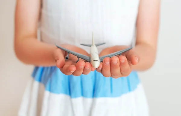 Menina segurando avião de brinquedo em suas mãos . — Fotografia de Stock