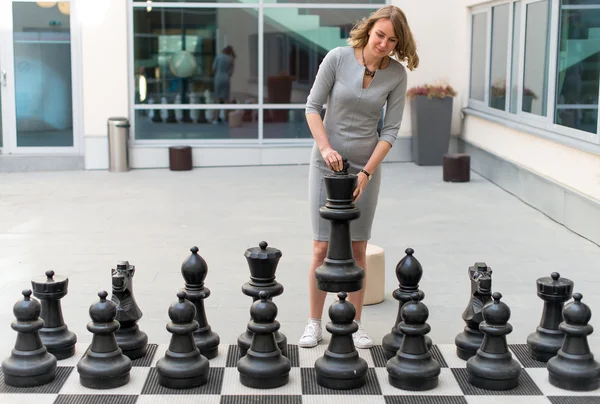 Mulher jogando jogo de xadrez ao ar livre . — Fotografia de Stock