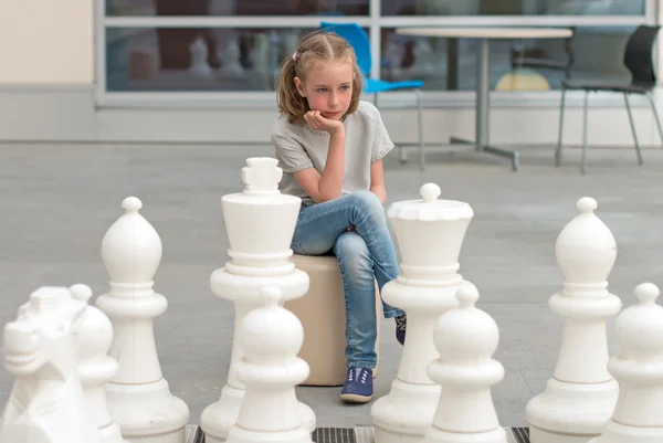 Kleines Mädchen beim Schachspiel im Freien. — Stockfoto