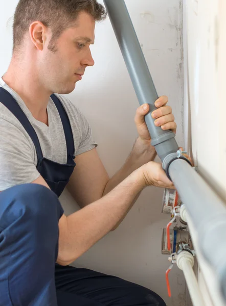 Male plumber assembling water pipes. — Stock Photo, Image