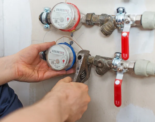 Fontanero macho fijando medidor de agua con llave ajustable. — Foto de Stock