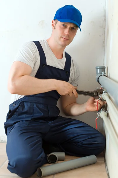 Male plumber fixing water meter with adjustable wrench. — Stock Photo, Image