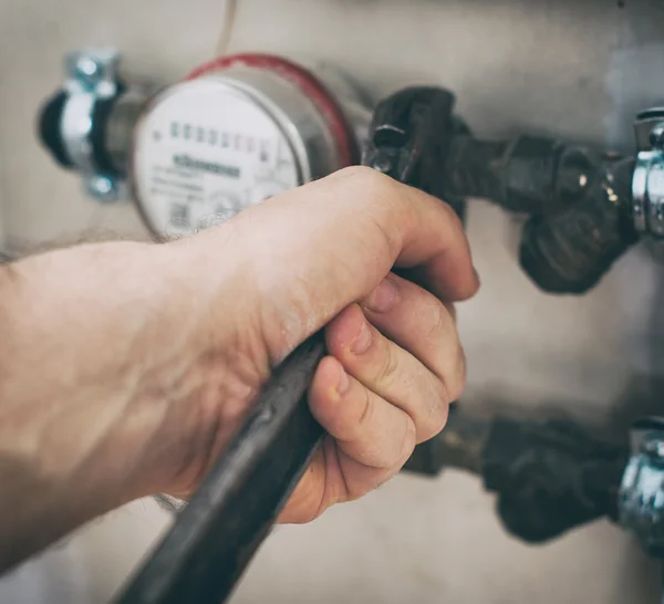 Fontanero macho fijando medidor de agua con llave ajustable. — Foto de Stock