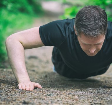 Yakışıklı adam ormandaki şınav.