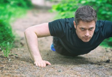 Yakışıklı adam ormandaki şınav.