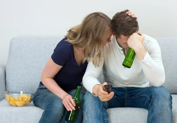 Trauriges Paar schaut Sportspiel im Fernsehen. — Stockfoto