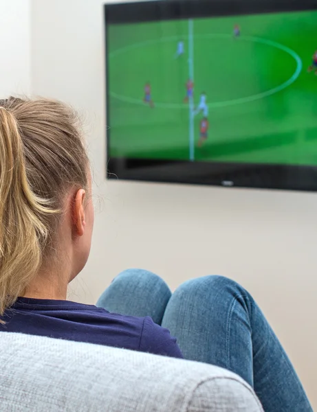 Mujer viendo el partido de fútbol en la televisión en casa . — Foto de Stock