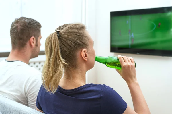 Casal assistindo jogo de futebol na televisão em casa . — Fotografia de Stock