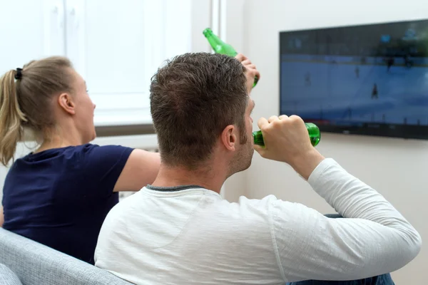 Casal animado assistindo jogo de hóquei na tv . — Fotografia de Stock