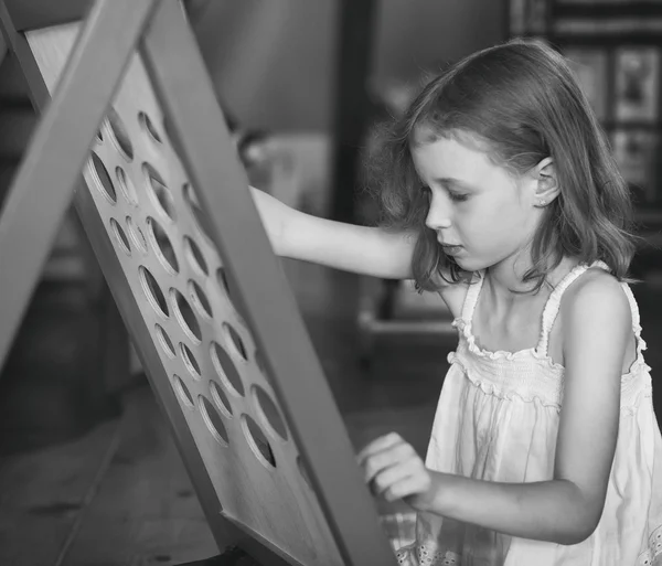 Dziewczynka bawi się w gry edukacyjne. Zdjęcie retro. — Zdjęcie stockowe