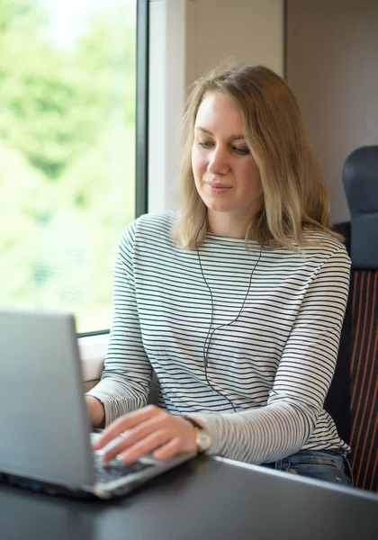 Woman using laptop while traveling by train. — Stock Photo, Image