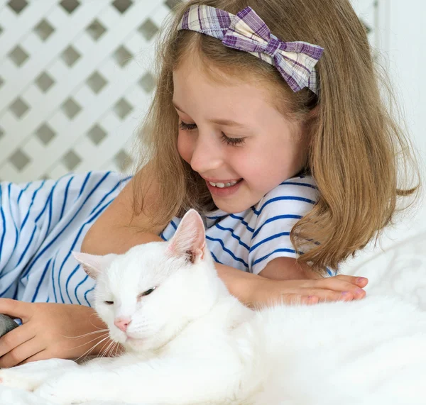 Little girl lying with cat on the bed. — Stock Photo, Image