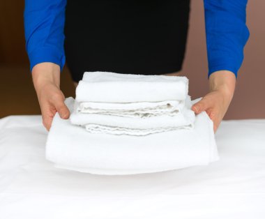 Oda servisi. Otel odasında havlu değiştiren bir kadın..