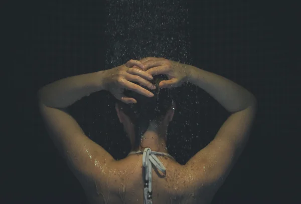 Młoda kobieta, ciesząc się pod prysznicem. Widok z tyłu. — Zdjęcie stockowe