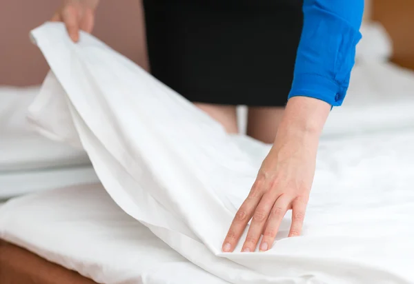 Обслуговування номерів. Жінка робить ліжко в готельному номері . — стокове фото